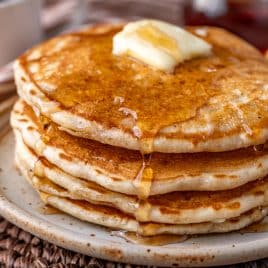 a plate of sourdough pancakes with butter and syrup