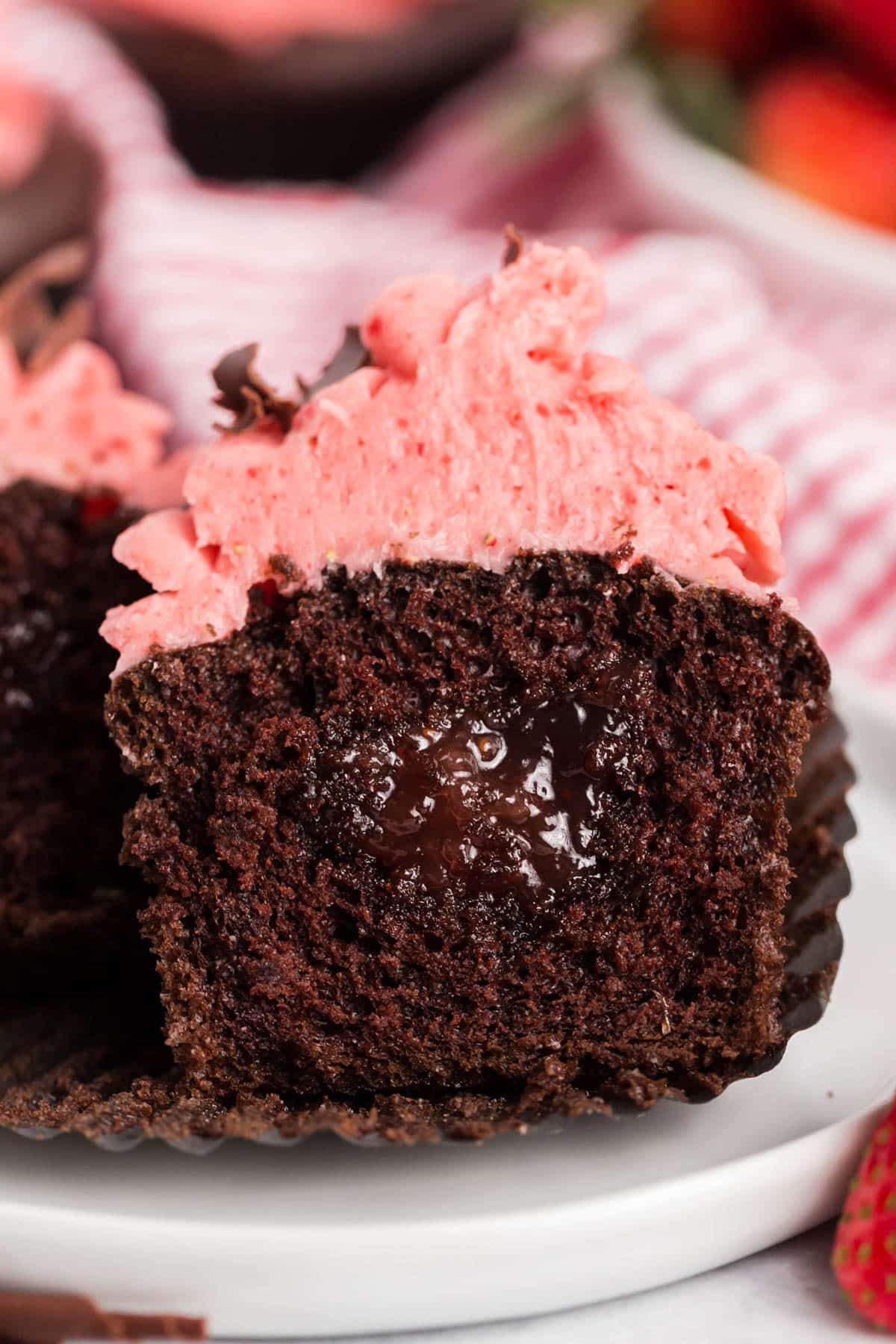 a chocolate strawberry cupcake cut in half to show jam filling