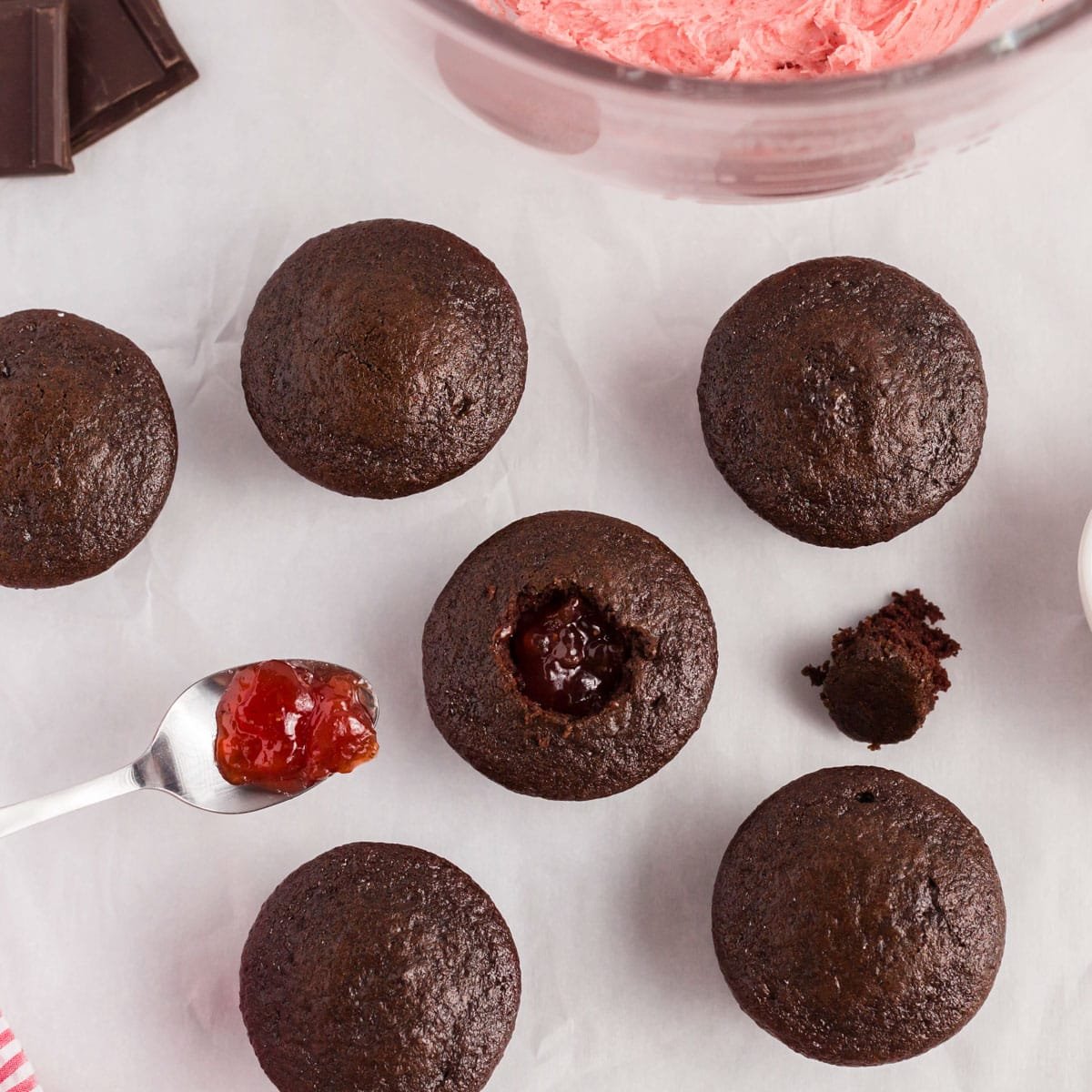 overhead view of chocolate cupcakes with strawberry jam spooned inside