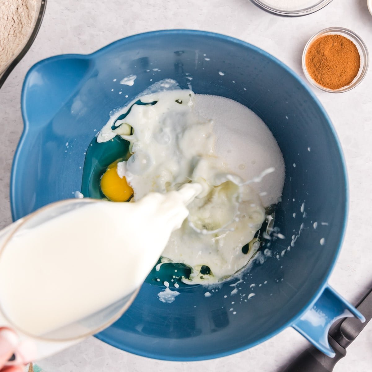 liquid ingredients in a bowl, with milk pouring in