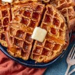 overhead view of a plate of waffles with butter and syrup