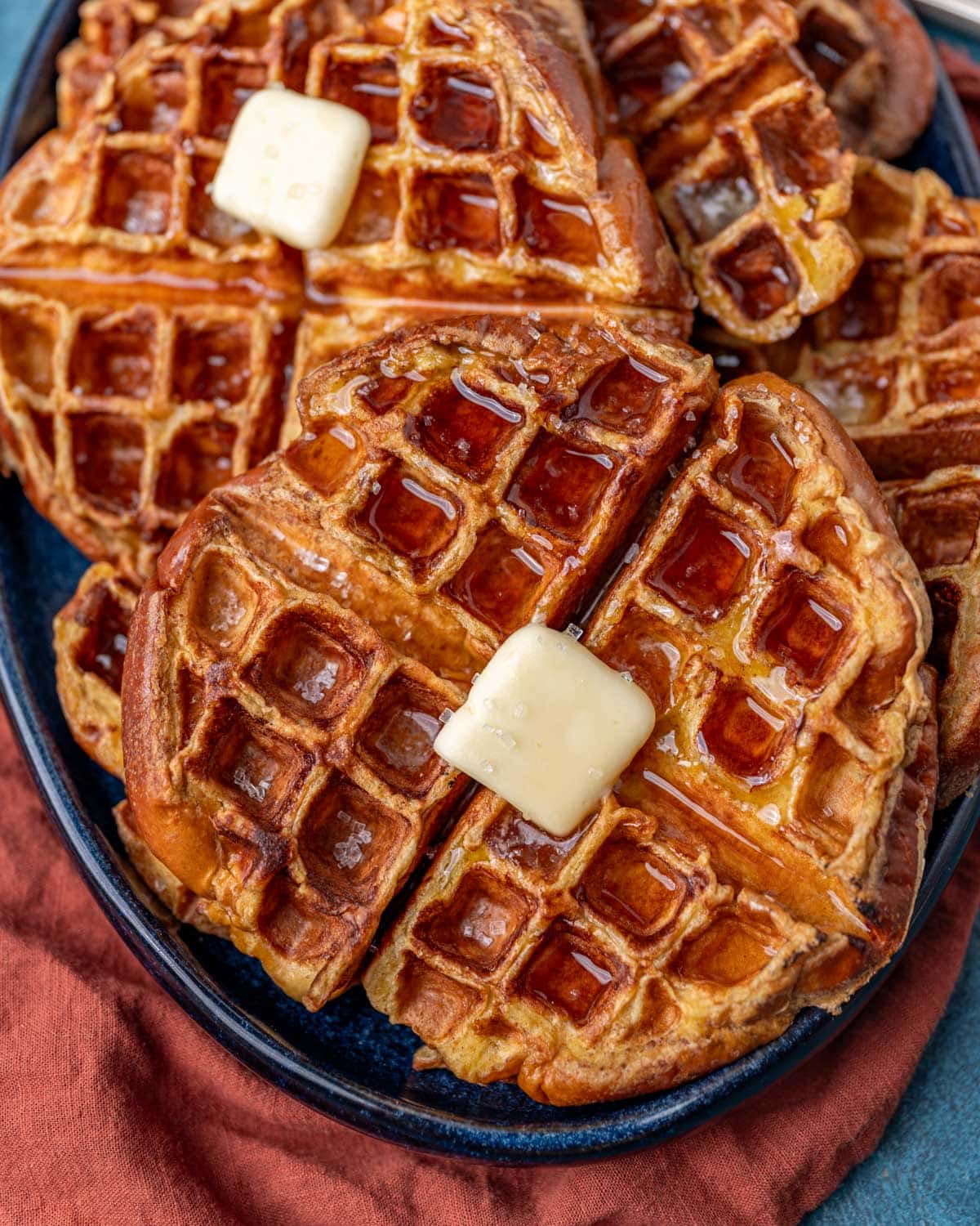 a plate of french toast waffles with butter and maple syrup