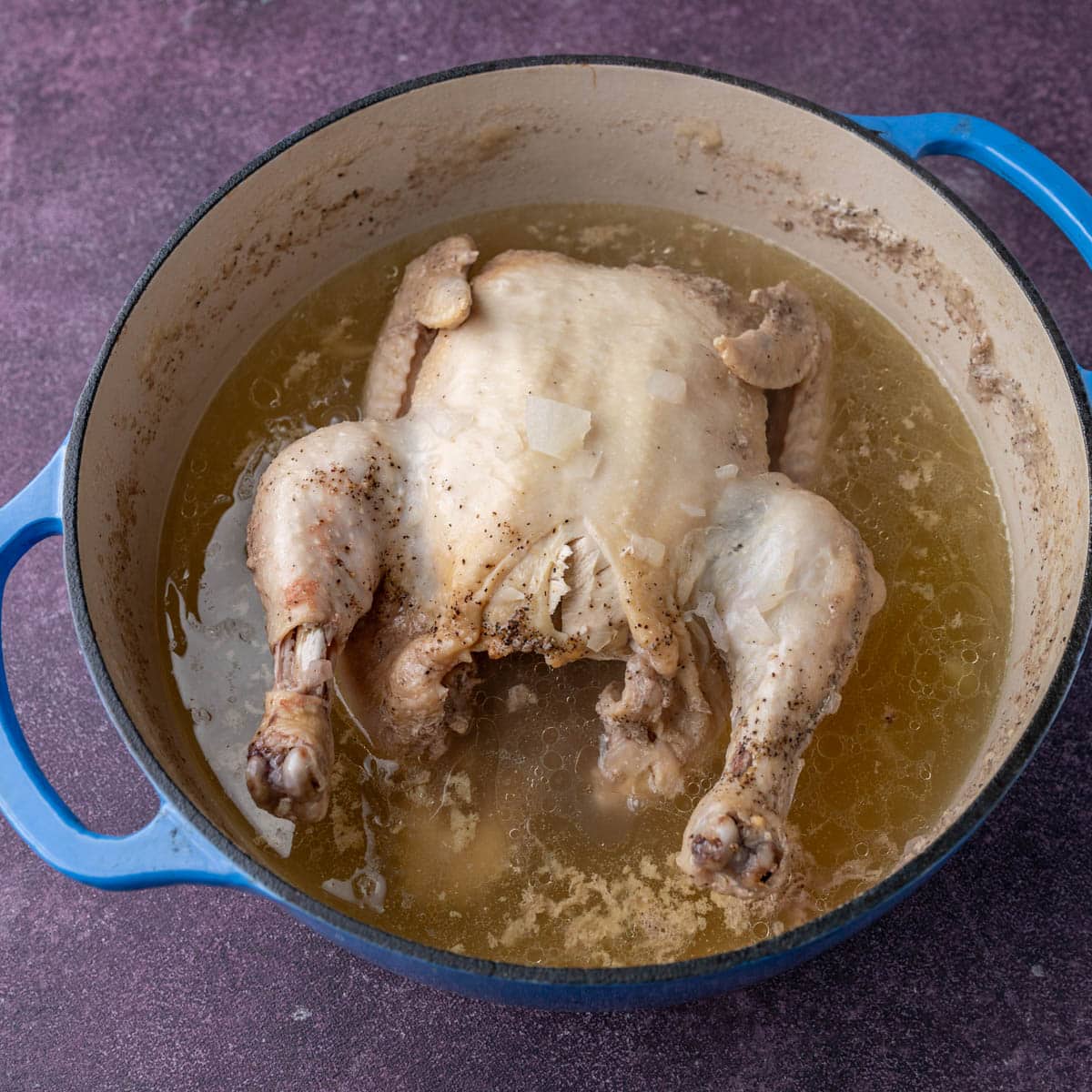 homemade chicken noodle soup with whole chicken in a pot