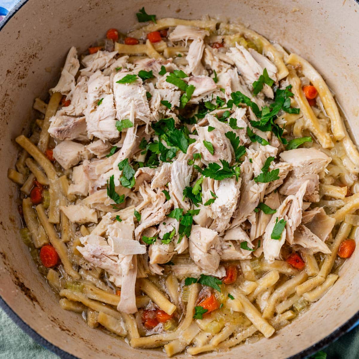 cooked egg noodles with diced chicken and fresh parsley
