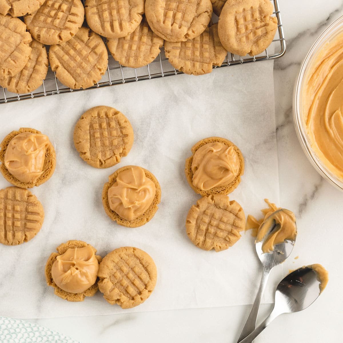 overhead view of spooning peanut butter filling on cookies to make sandwiches