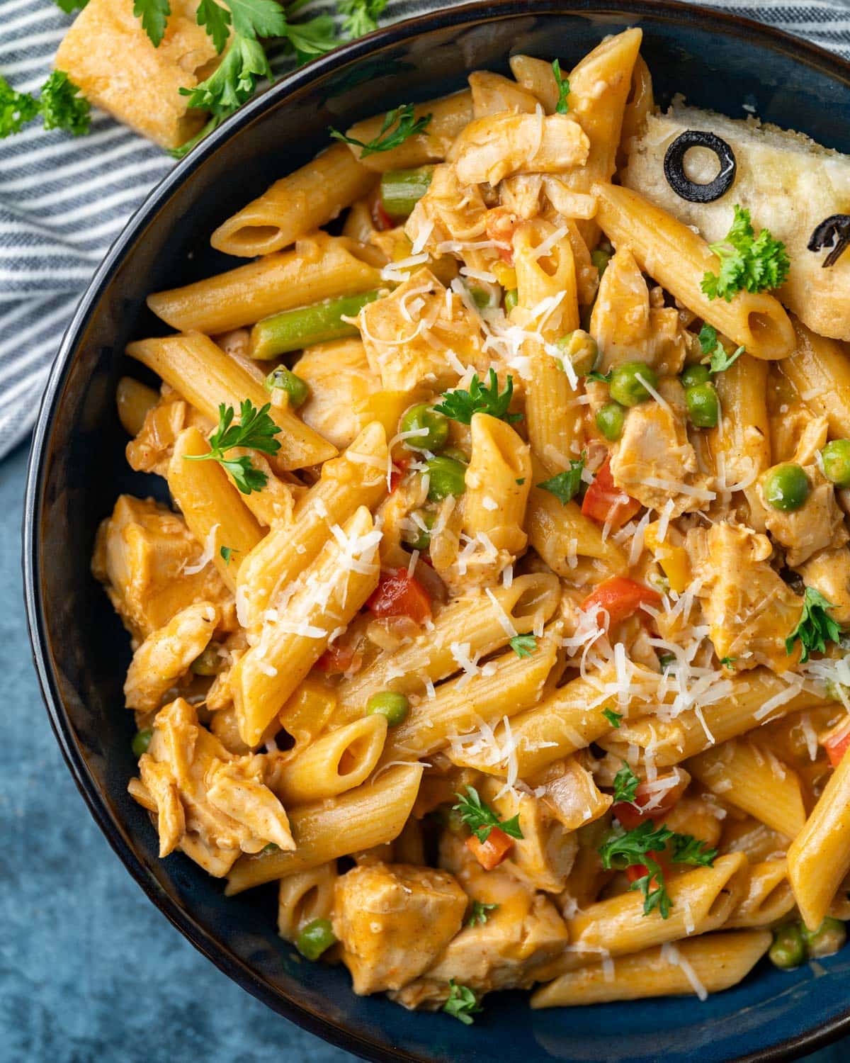 spicy chipotle chicken pasta in a bowl with parmesan and parsley