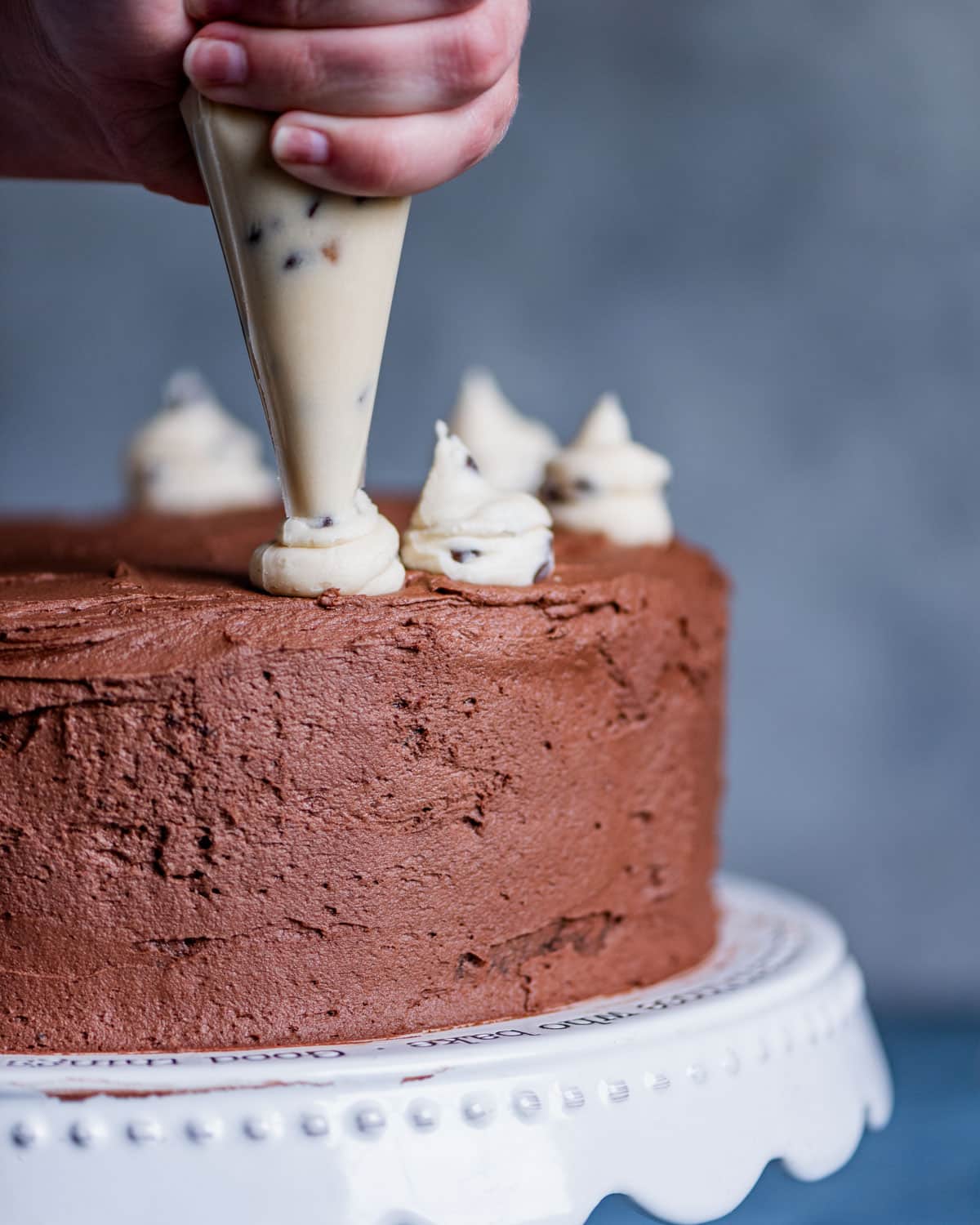 dolloping cookie dough frosting around top of cake