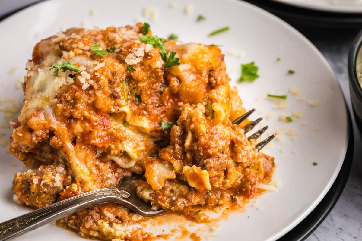 a piece of lasagna on a plate with a fork