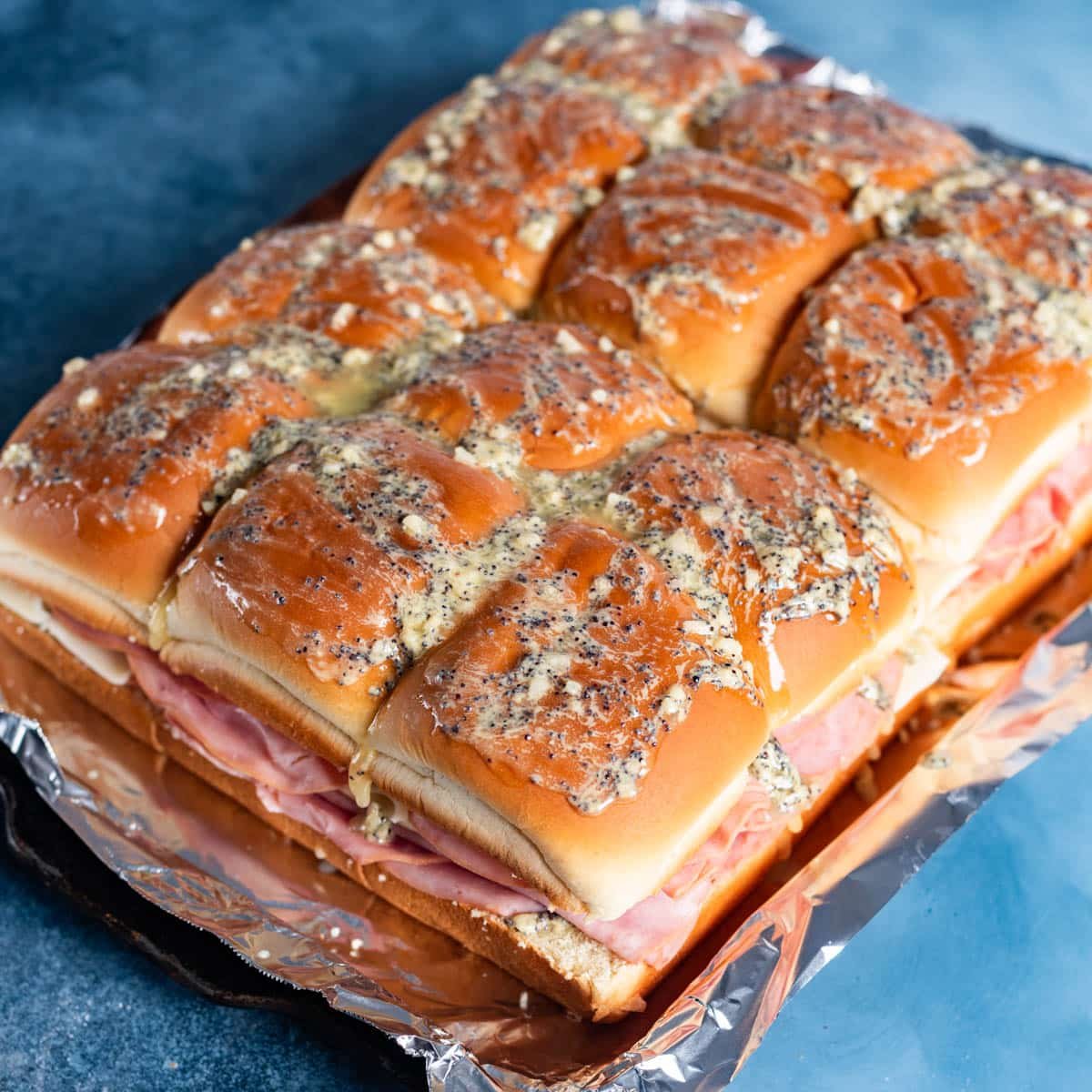 unbaked ham sliders on a baking sheet