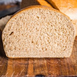 a slice of honey wheat bread on a cutting board