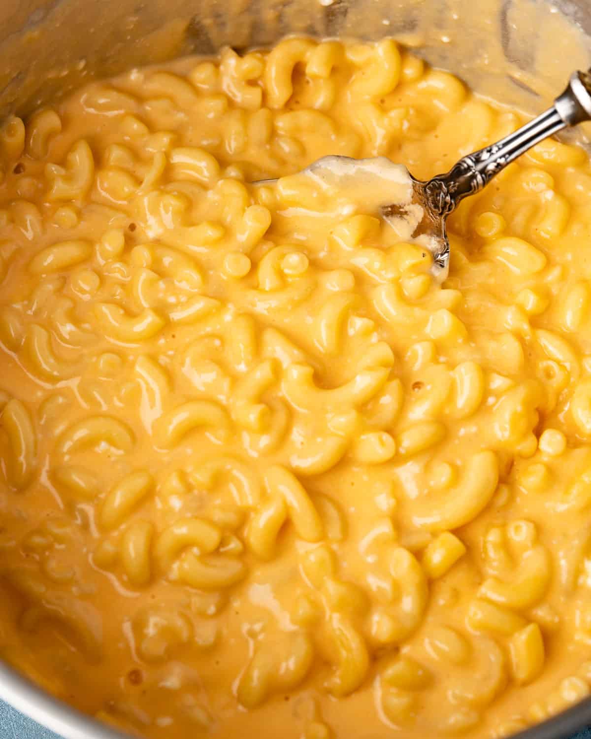 creamy macaroni and cheese in a pot with a spoon