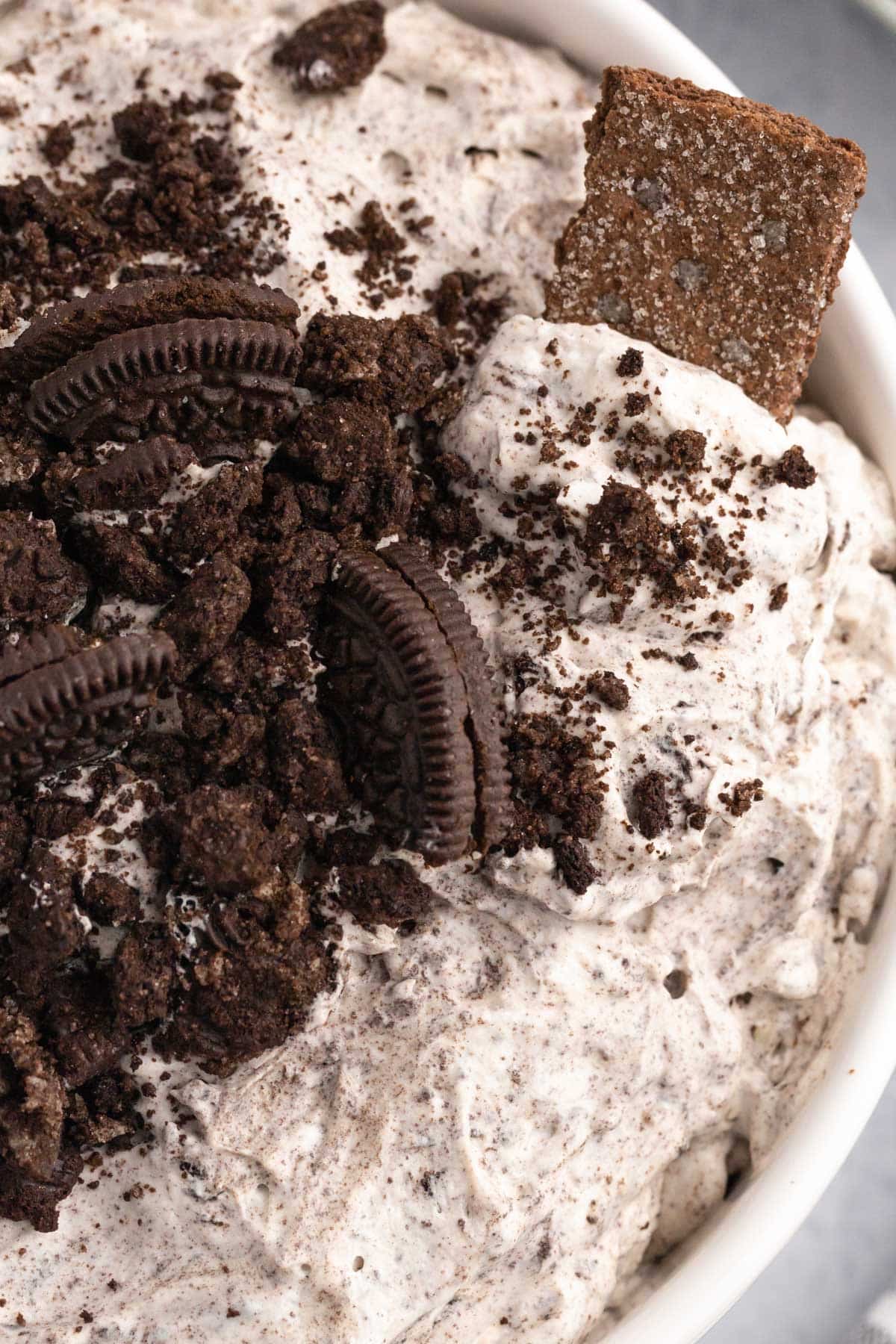 closeup of oreo fluff dessert salad in a bowl with a graham cracker