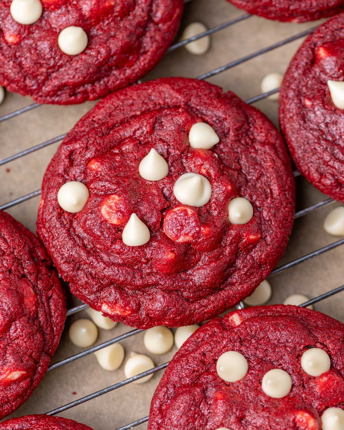 overhead view of red velvet cookies with white chocolate chips on a wire rack