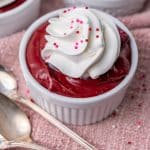 a small bowl of red velvet pudding with whipped cream and sprinkles
