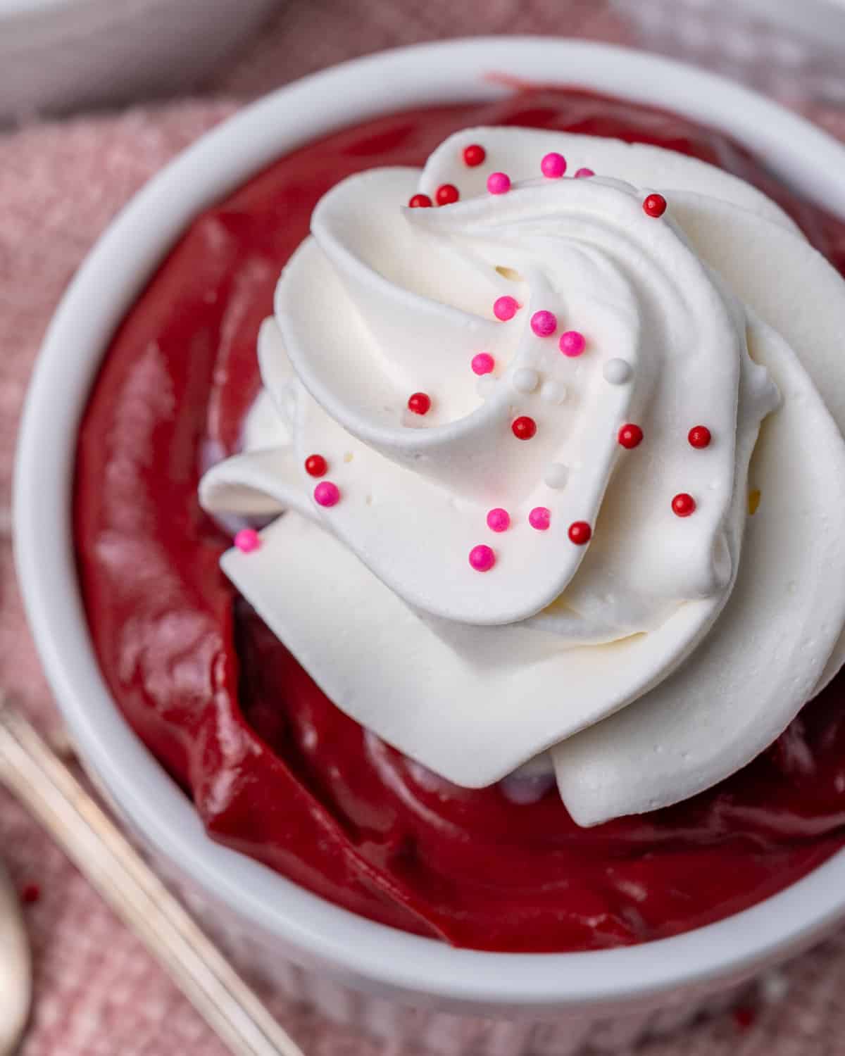 a closeup of red velvet pudding with whipped cream