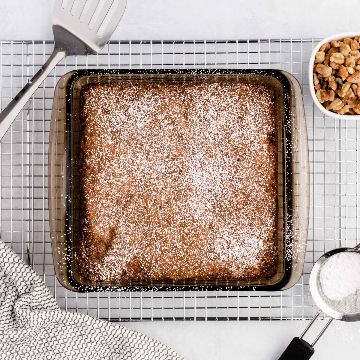 overhead view of a carrot walnut cake with a dusting of powdered sugar