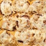 overhead view of carrot cake cinnamon rolls with frosting and walnuts