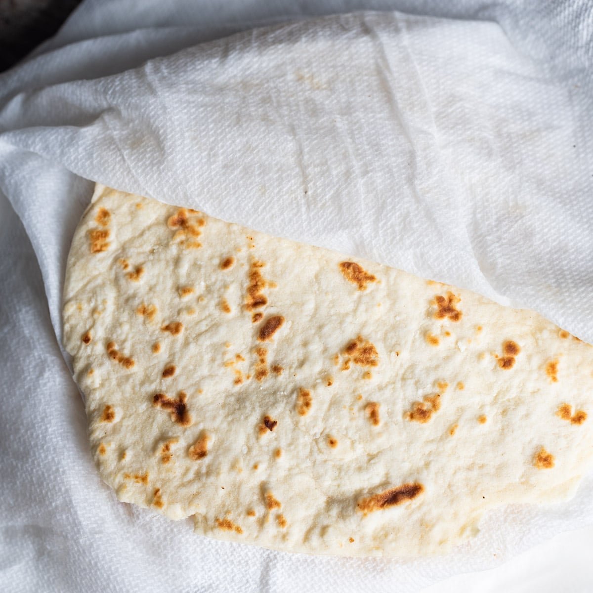 cooked flour tortillas in damp paper towels