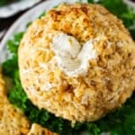 closeup of garlic cheese ball with a cracker in it