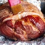 brushing ham glaze over an oven baked ham