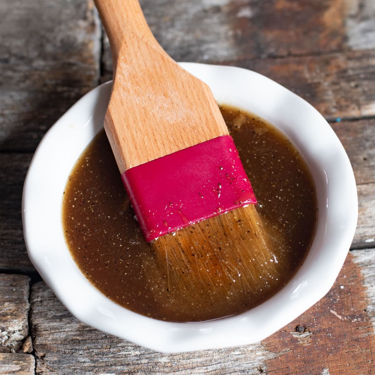 easy ham glaze in a white bowl with a pastry brush