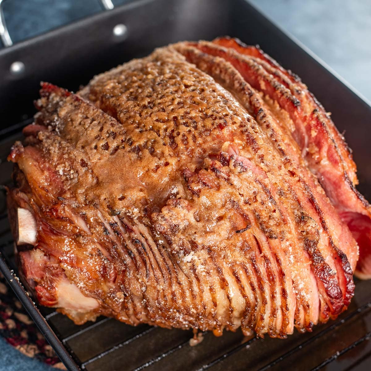 a homemade honey baked ham in a roasting pan