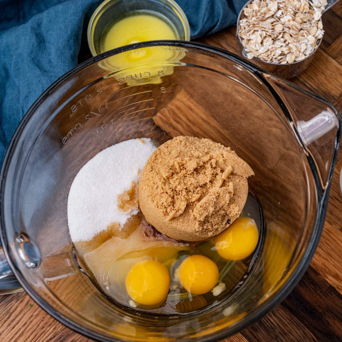 brown sugar, white sugar and eggs in a glass mixing bowl