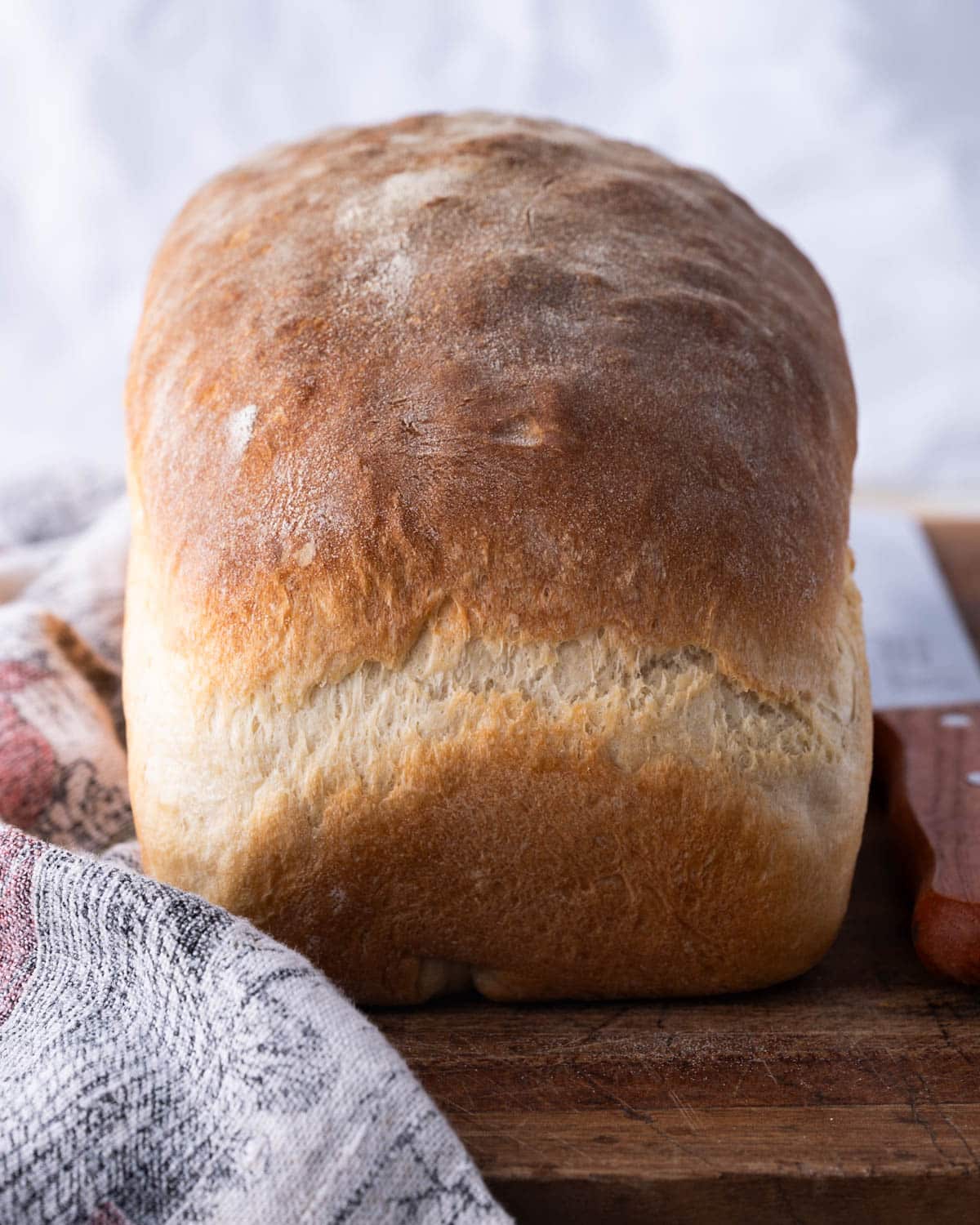 a loaf of homemade white bread on a cutting board