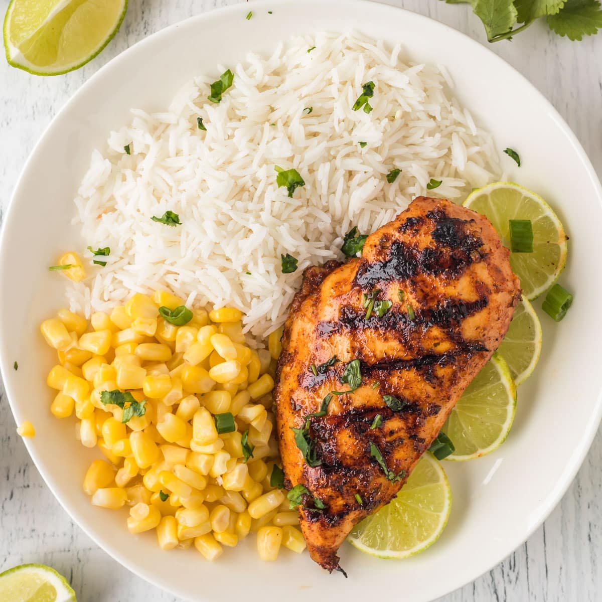 overhead view of a plate of chicken, rice and corn