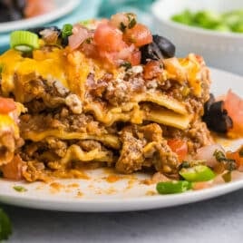 a piece of mexican lasagna sitting on a plate