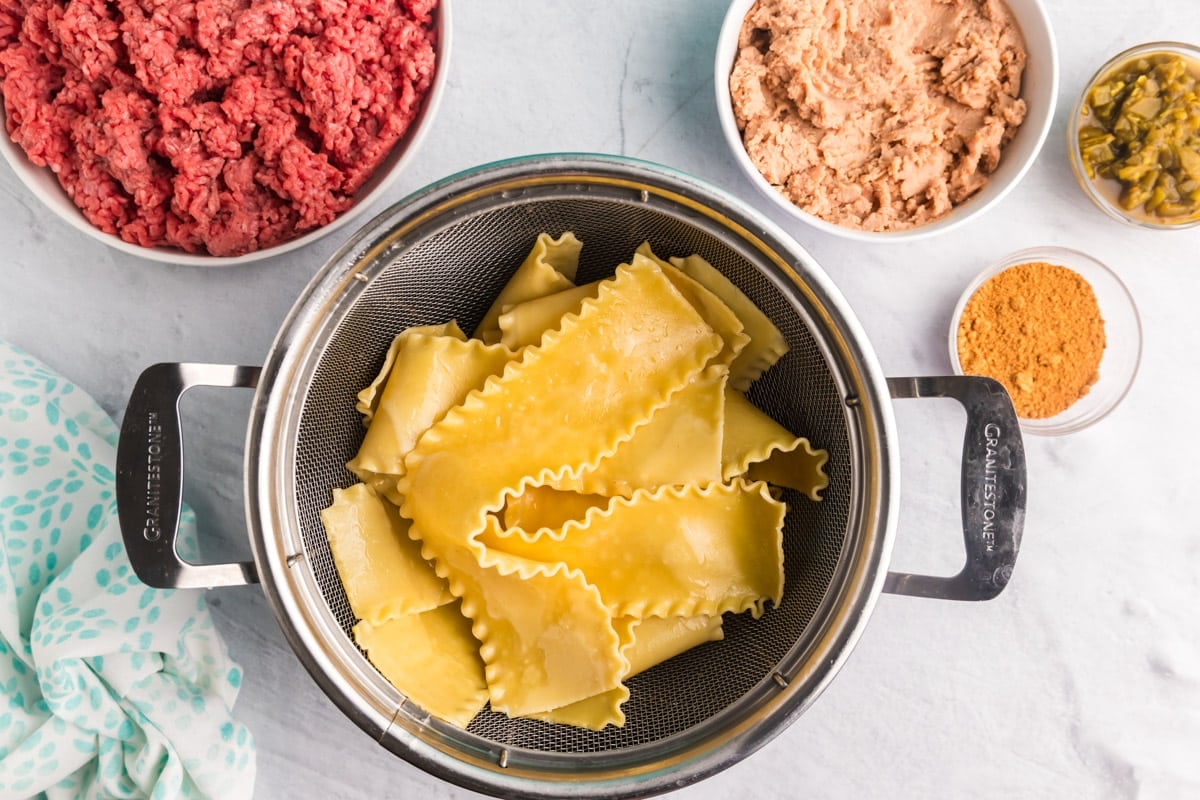 cooked lasagna noodles draining in a strainer