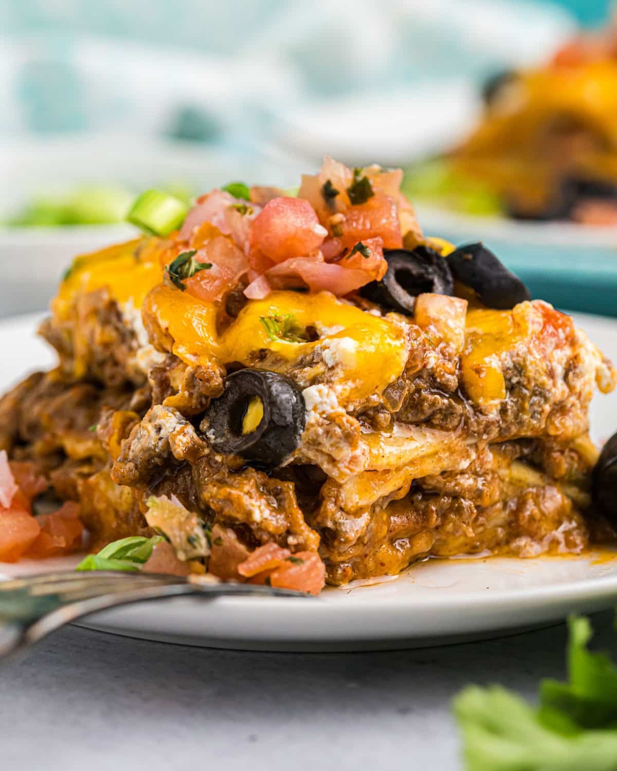 mexican lasagna with olives and tomatoes on a plate