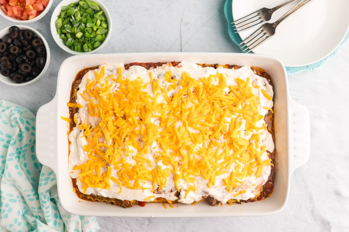 mexican lasagna with sour cream and cheese on top