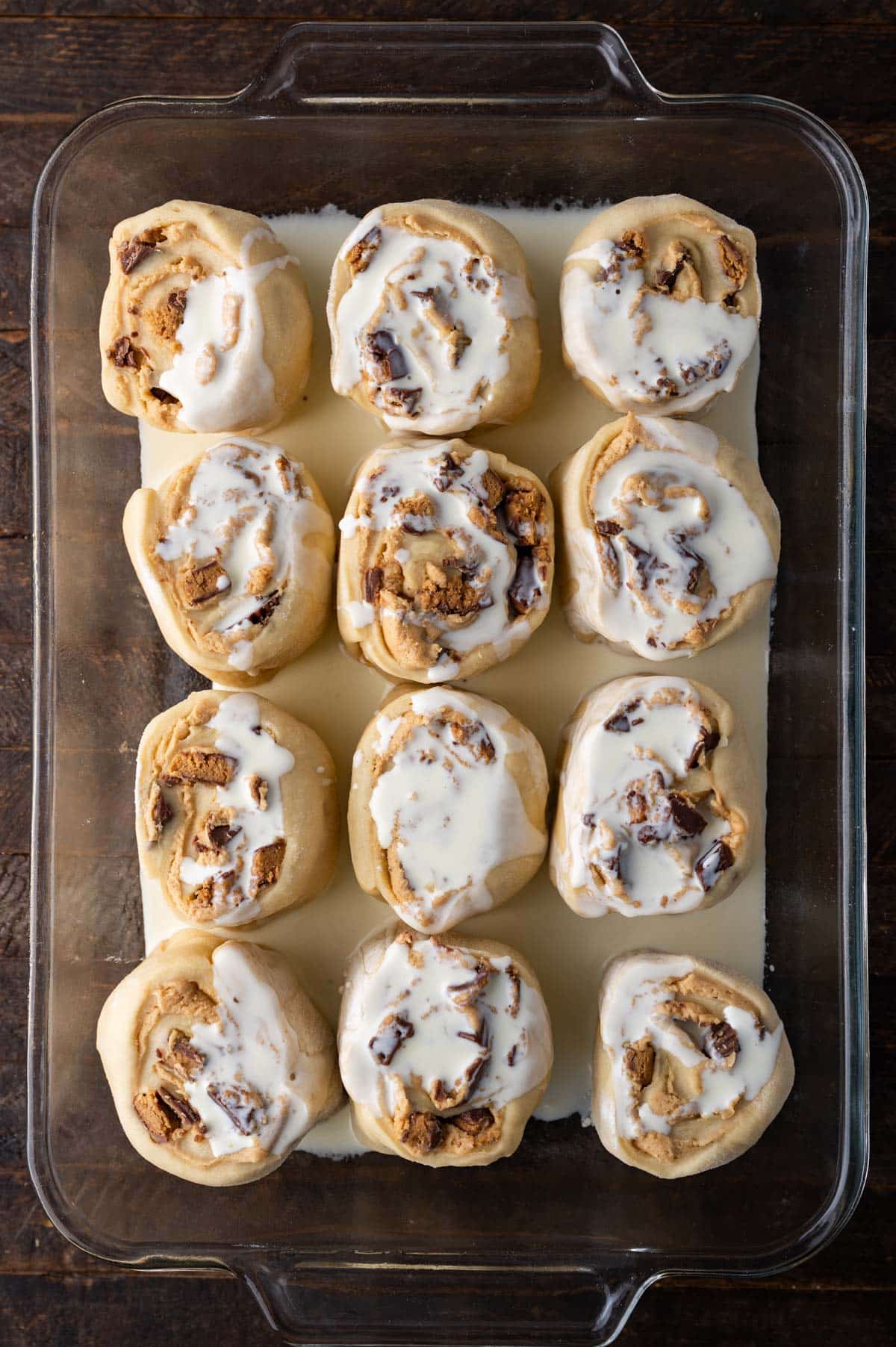 reese's sweet rolls in a pan with heavy cream poured over the top