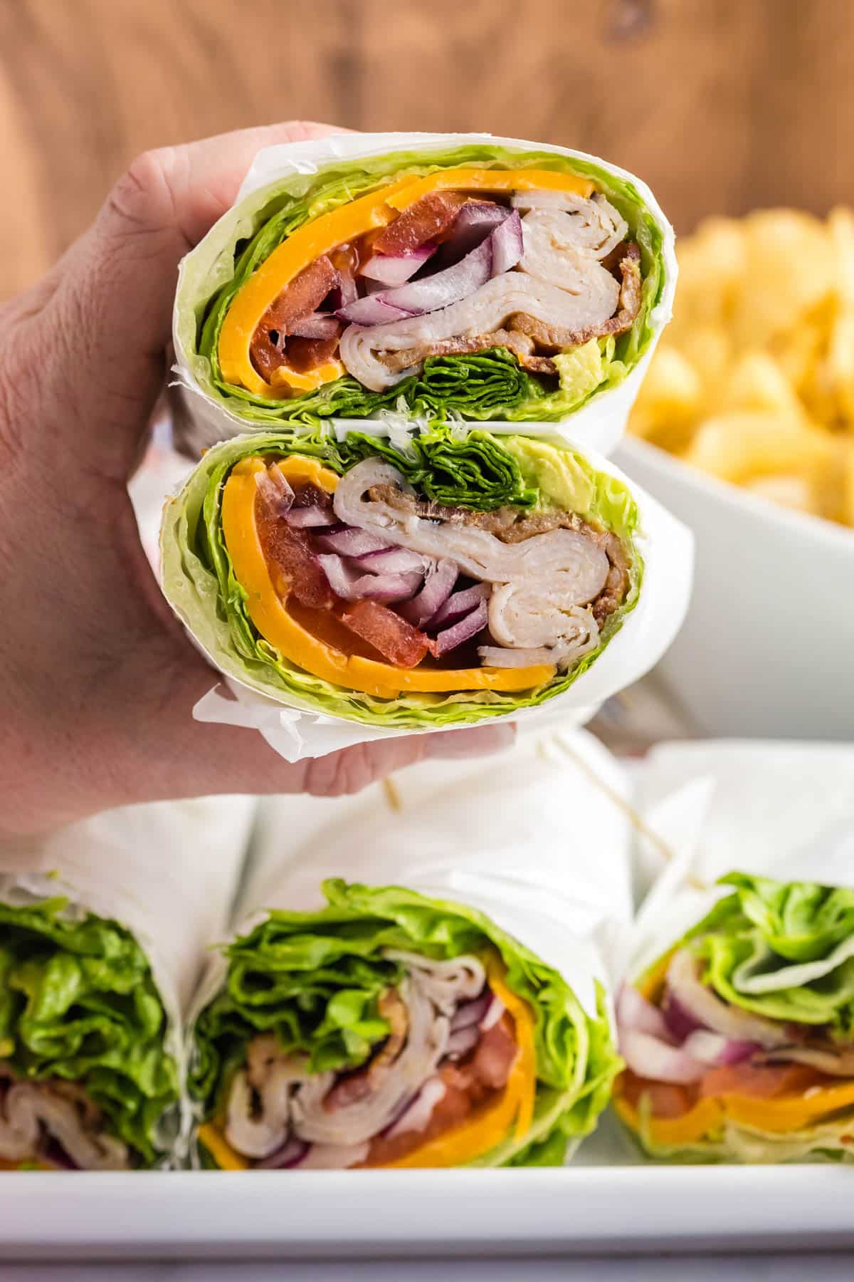 a hand holding lettuce wrap in parchment paper