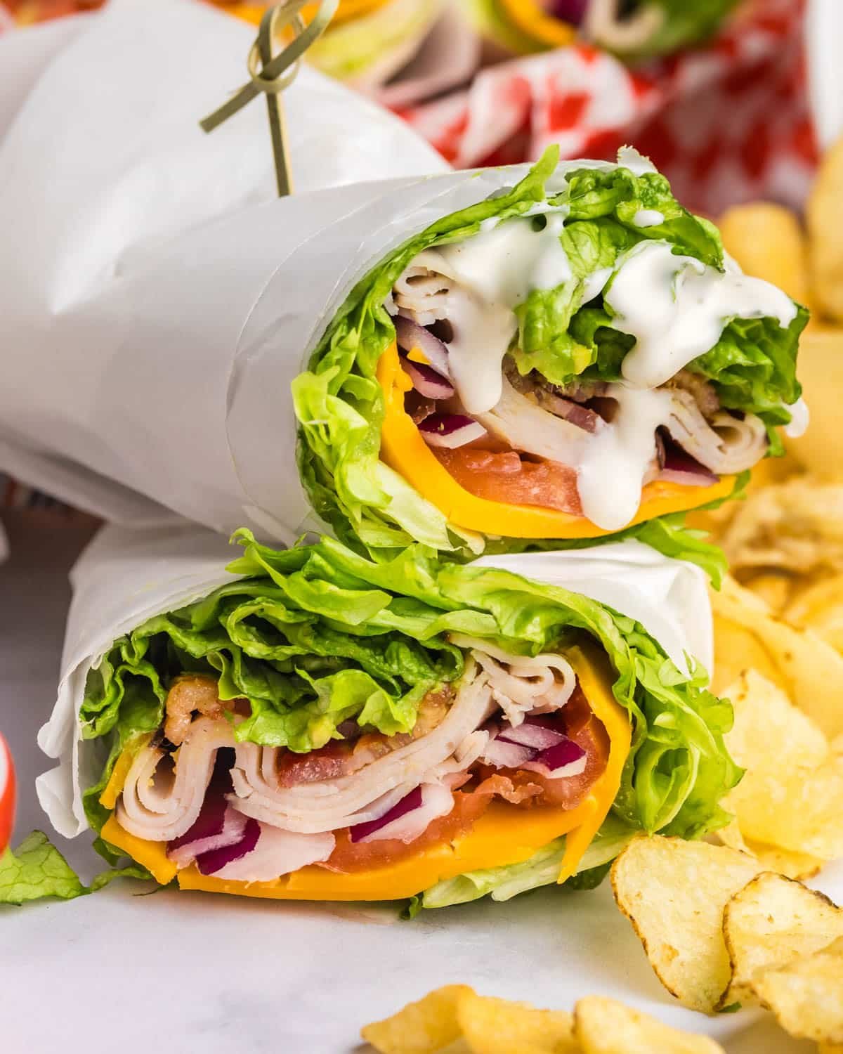 a lettuce wrap on a table with ranch dip and potato chips