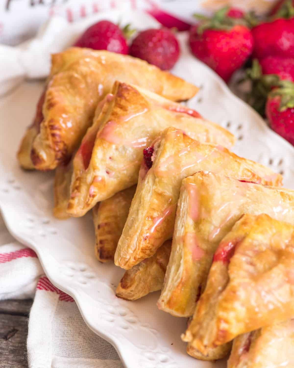 strawberry turnovers lined up on a white plate