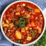 overhead view of a bowl of summer chili with fresh herbs on top