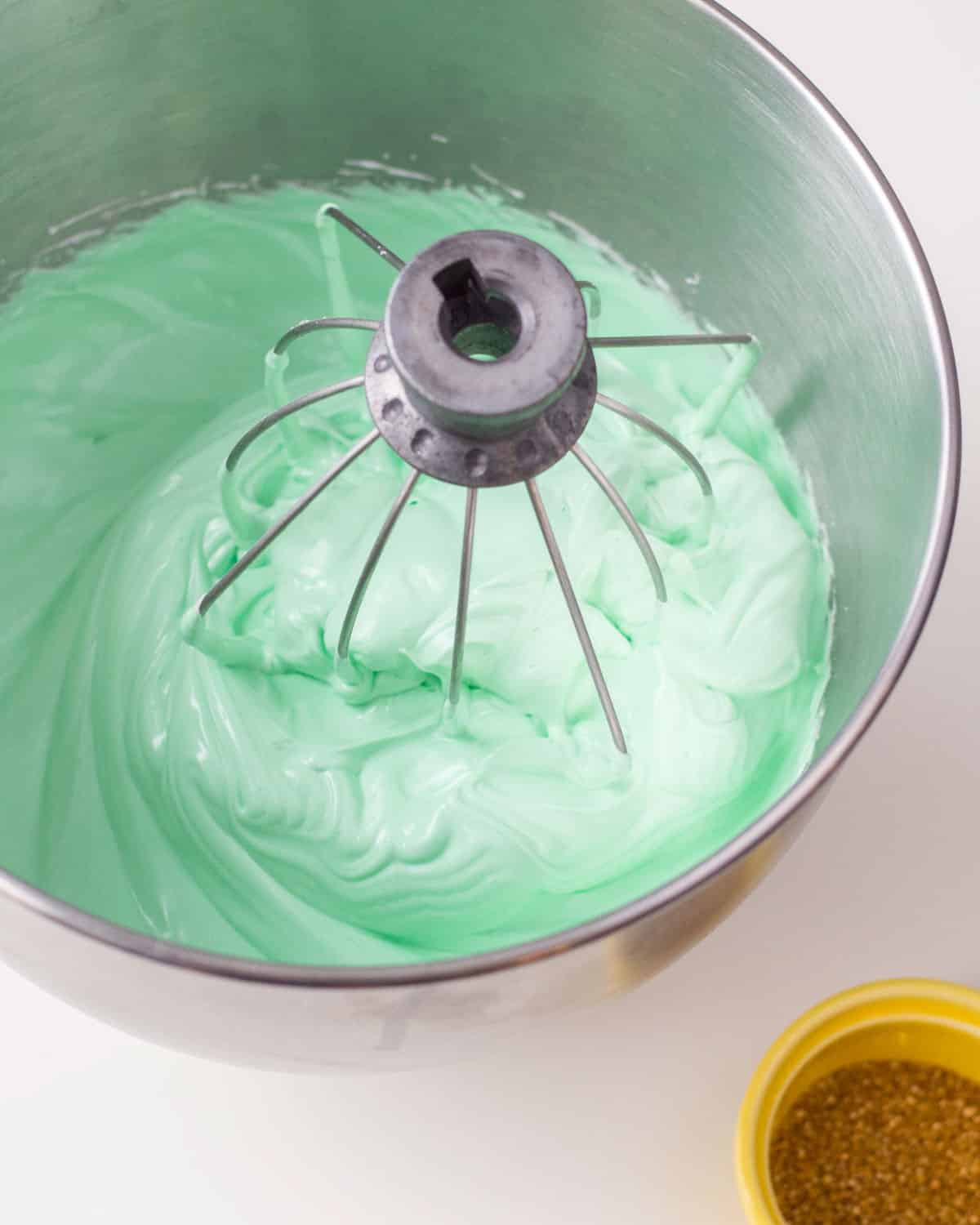 whipped egg whites and sugar in a bowl with a whisk