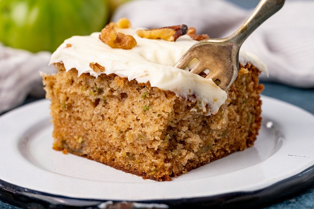 a piece of green tomato cake on a plate with a fork