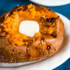a baked sweet potato on a plate with butter