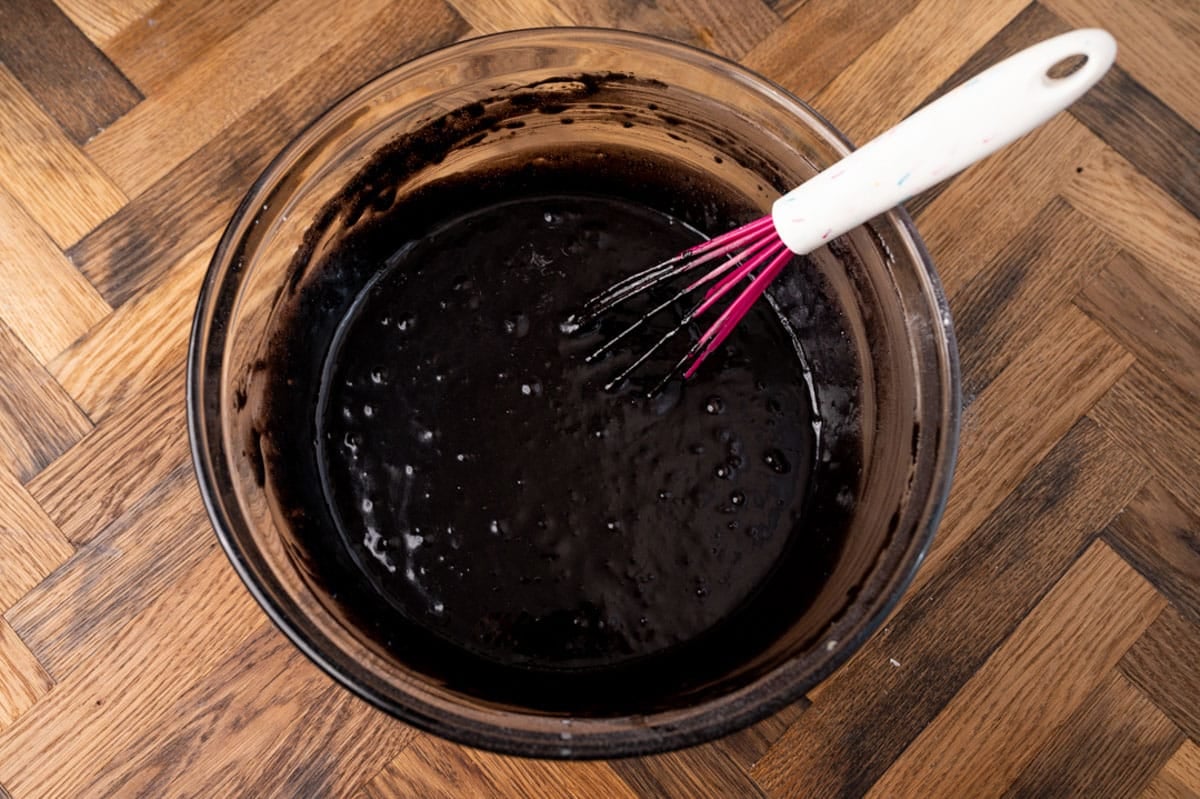 chocolate cake batter in a bowl with a whisk