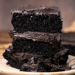 closeup of black chocolate cake with frosting on a plate