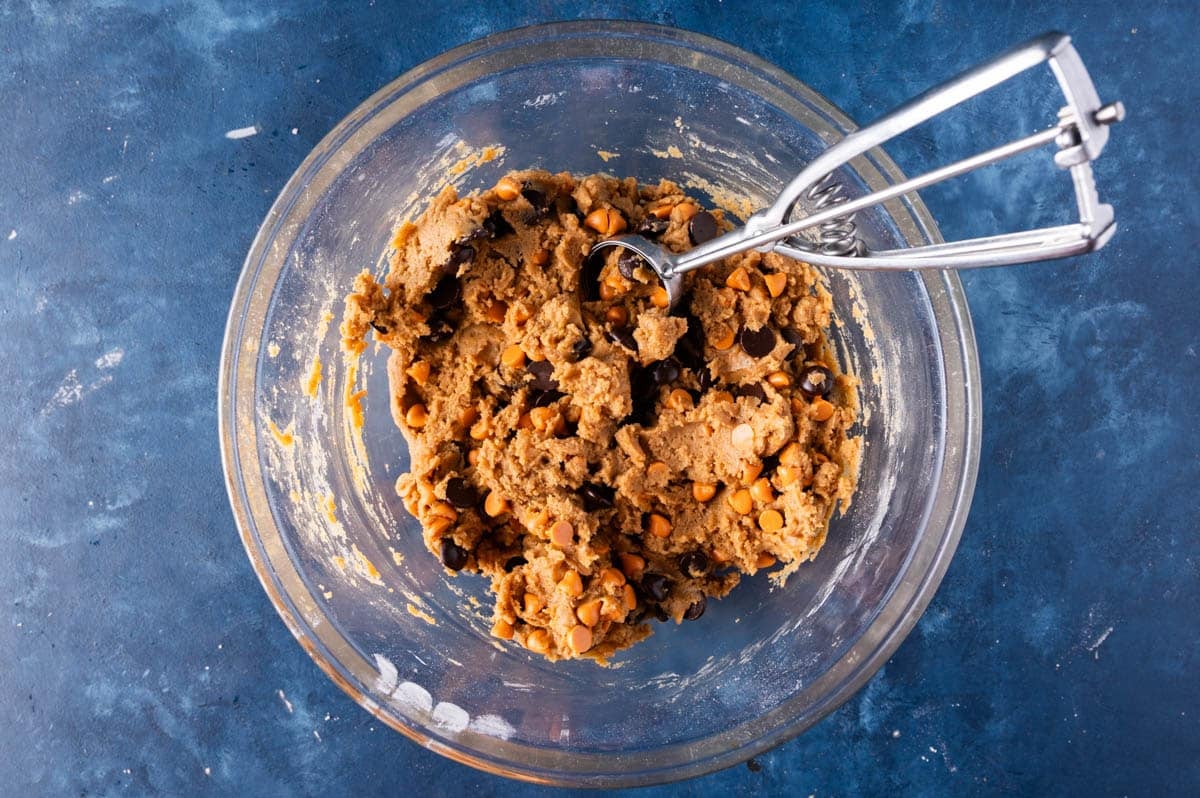 cookie dough in a bowl with a cookie scoop