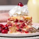 cranberry christmas cake on a plate with whipped cream