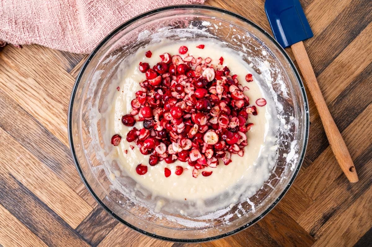 chopped cranberries on top of cake batter in a bowl