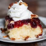 a piece of cranberry upside down cake on a plate with whipped cream