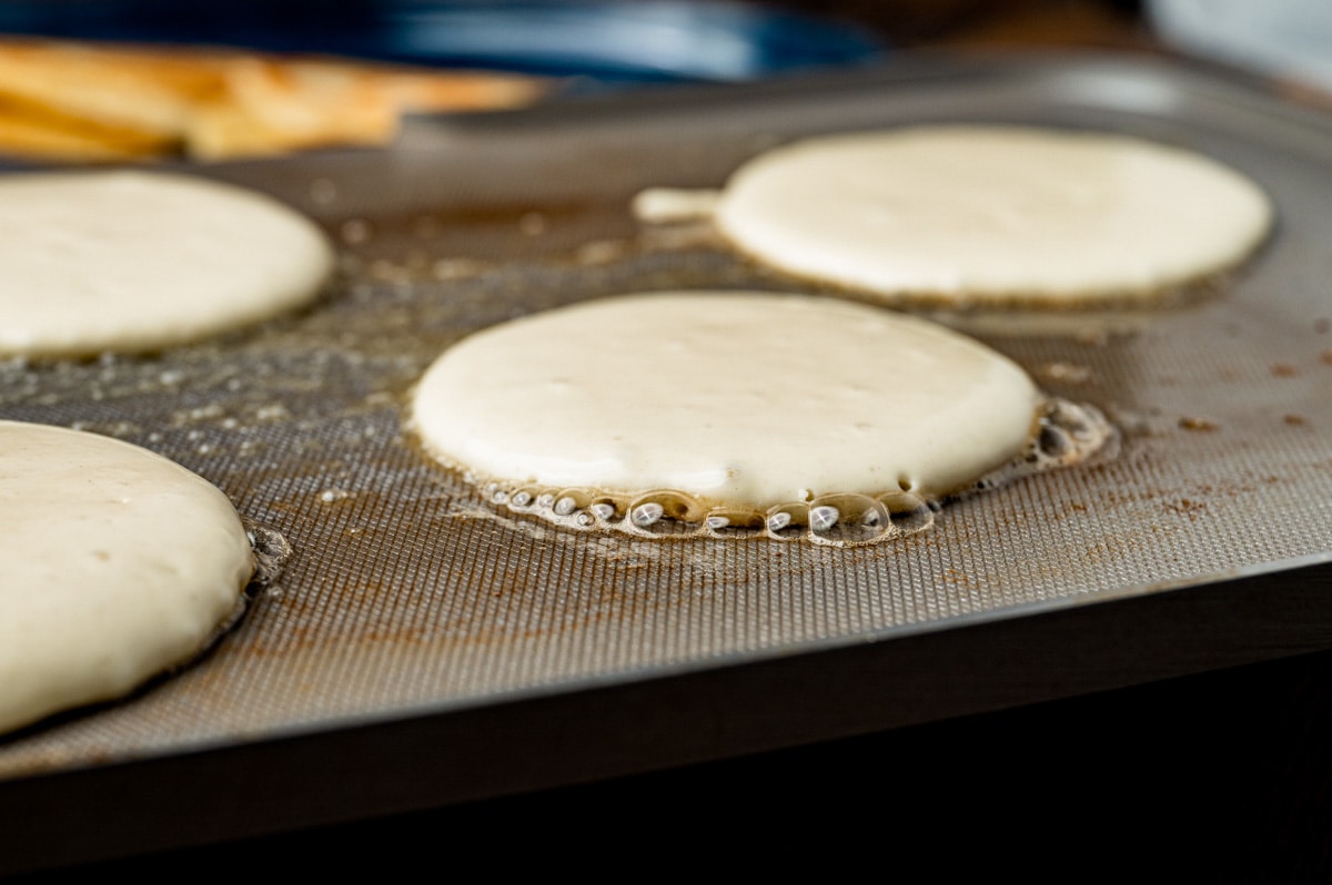 pancakes cooking on a griddle