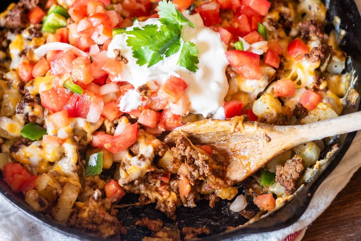 mexican potato skillet in a cast iron pan with a spoon