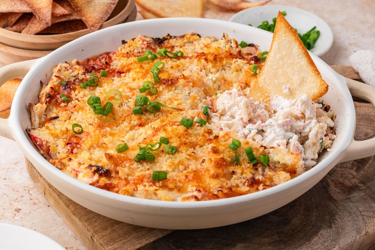 crab rangoon dip in a bowl with a chip